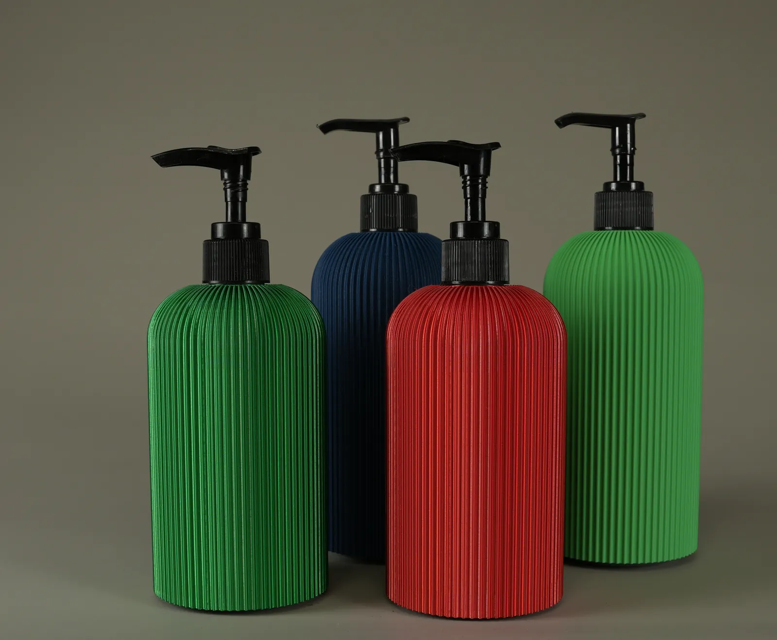 Four covered soap bottles — Silk+ green and red for the holidays, with matte green and dark blue behind