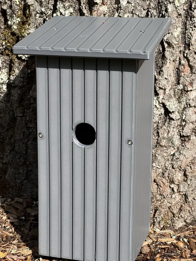 Finished gray house mounted outdoors on a tree
