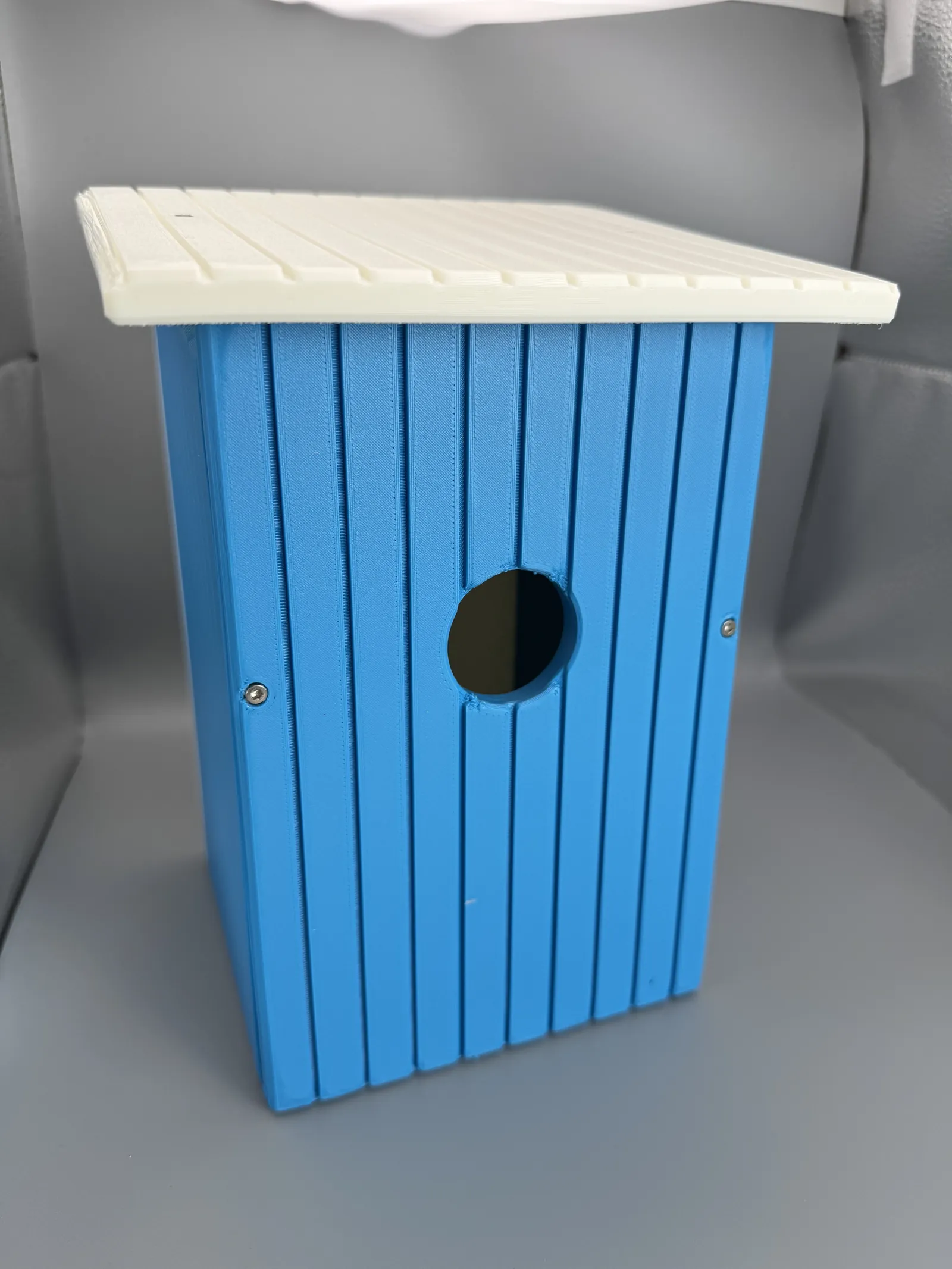 A blue Eastern Bluebird house standing on the workbench